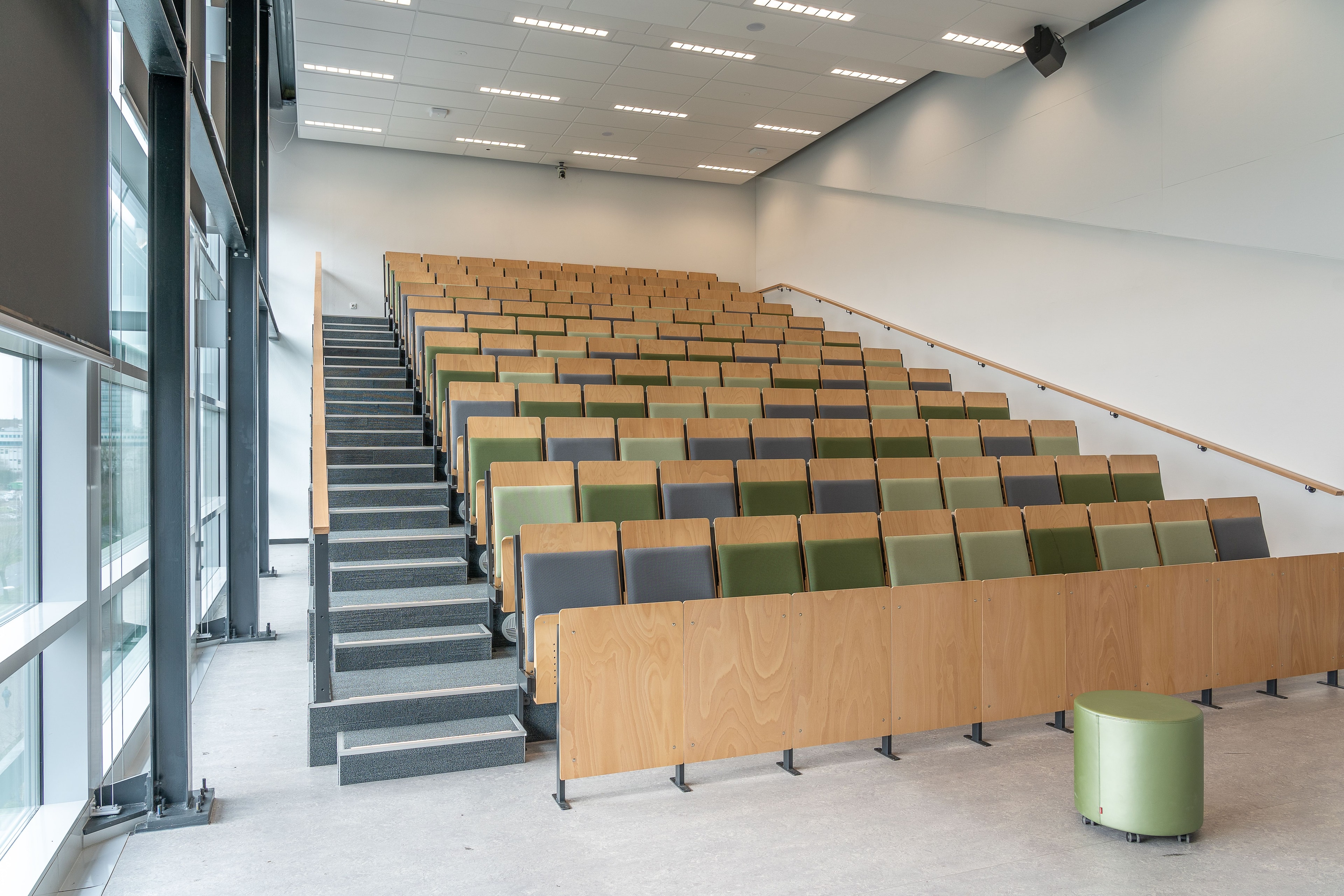 Aula magna con sedute in legno e tessuto verde oliva