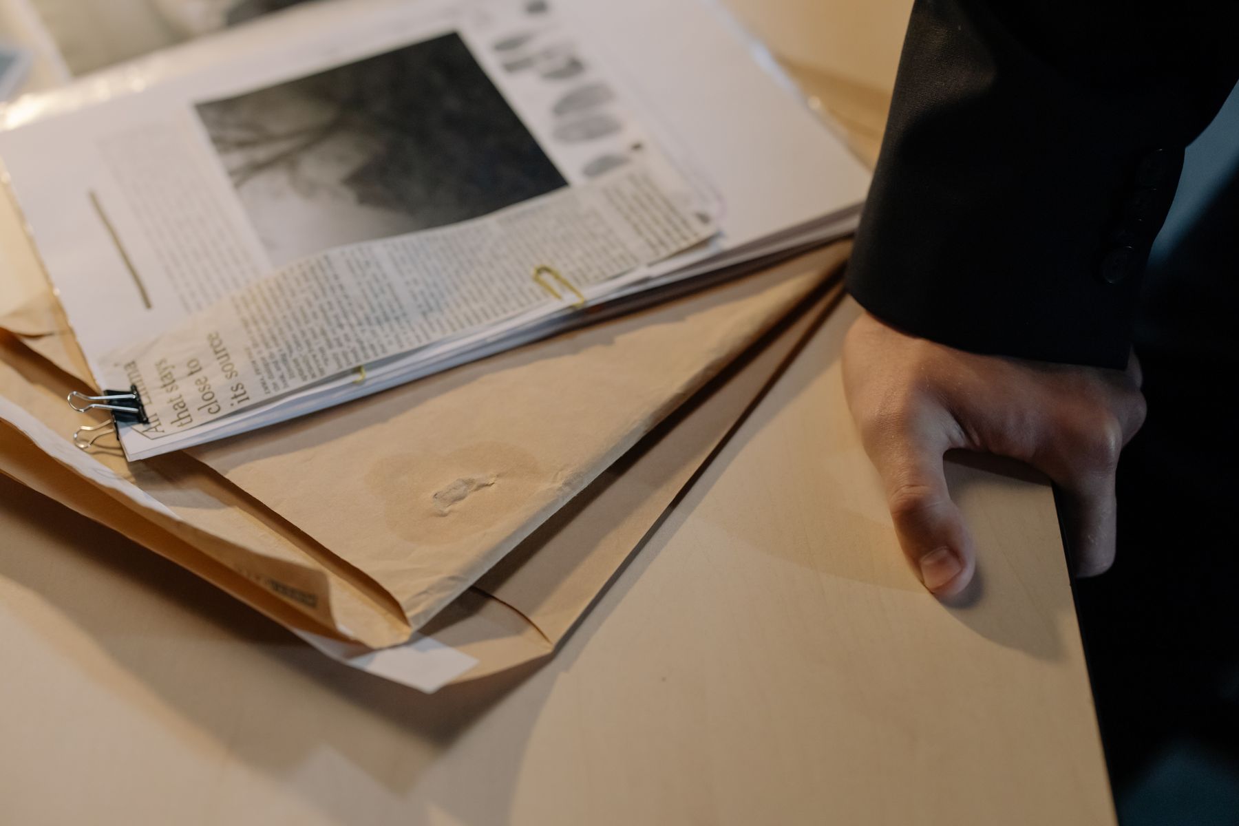 Fascicolo di documenti e ritagli di giornale su una scrivania