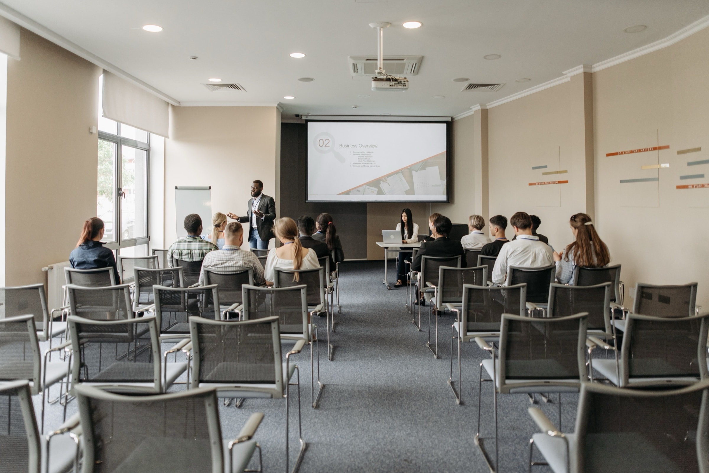 Partecipanti seduti in una sala seminari davanti allo schermo di una presentazione