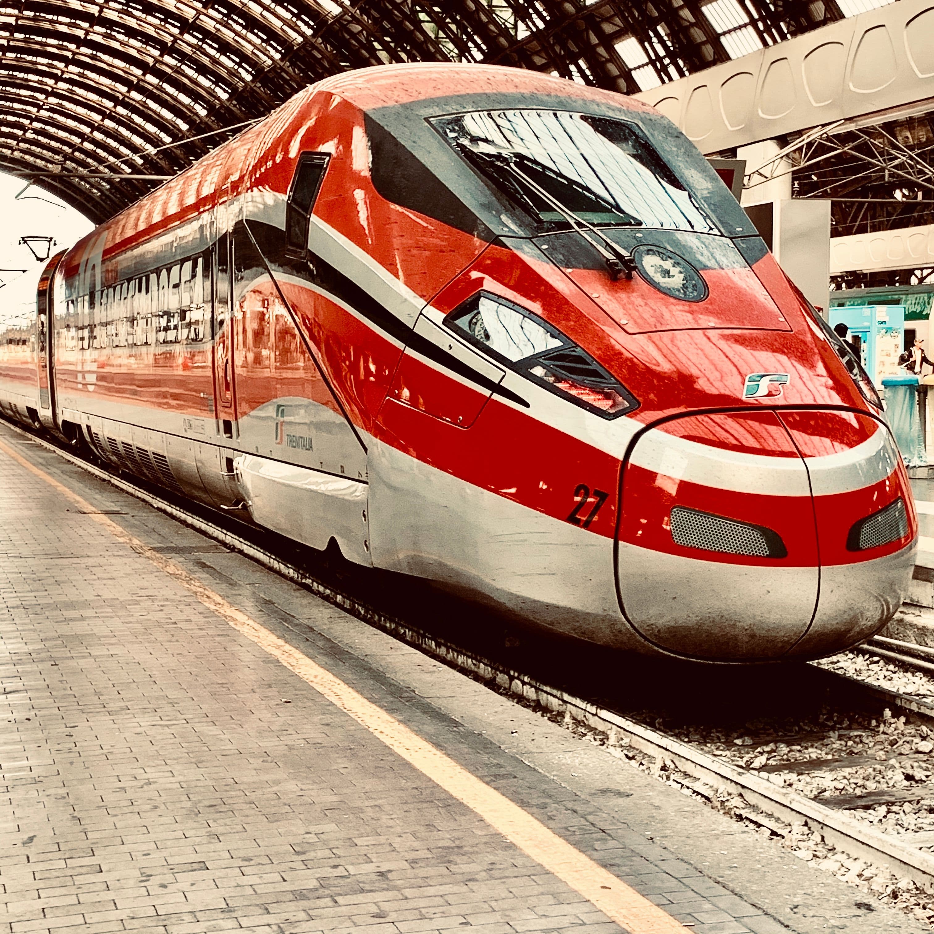 Treno Frecciarossa rosso in sosta sotto la volta di Milano Centrale