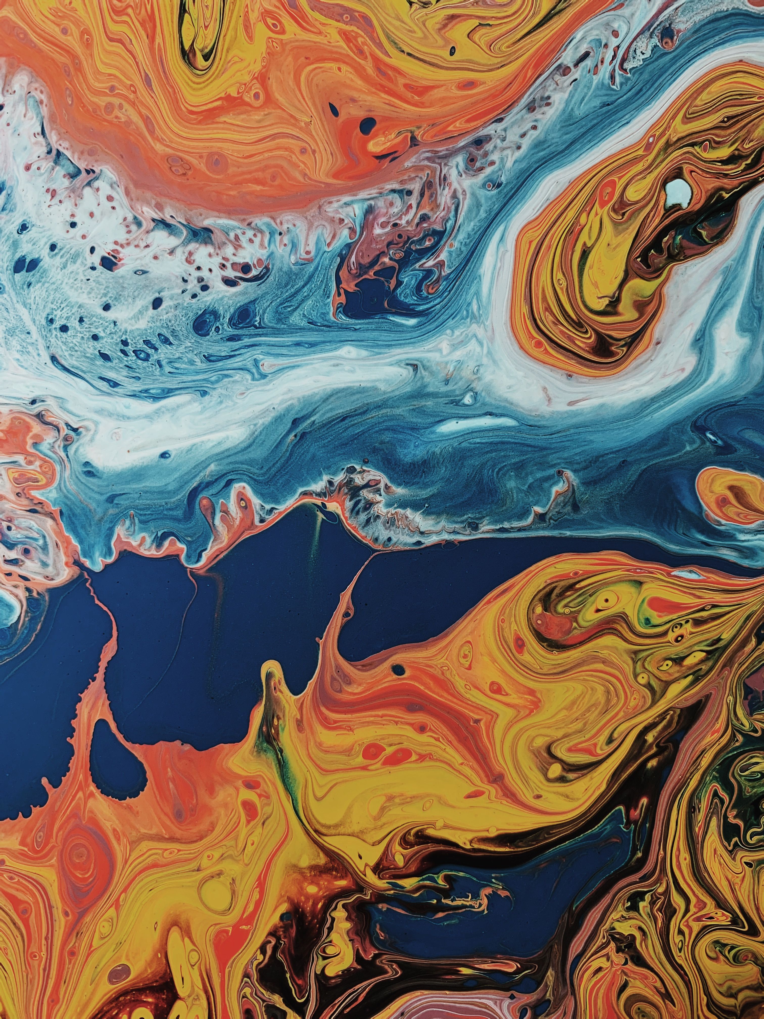 Vortice astratto di pittura arancione, giallo e blu