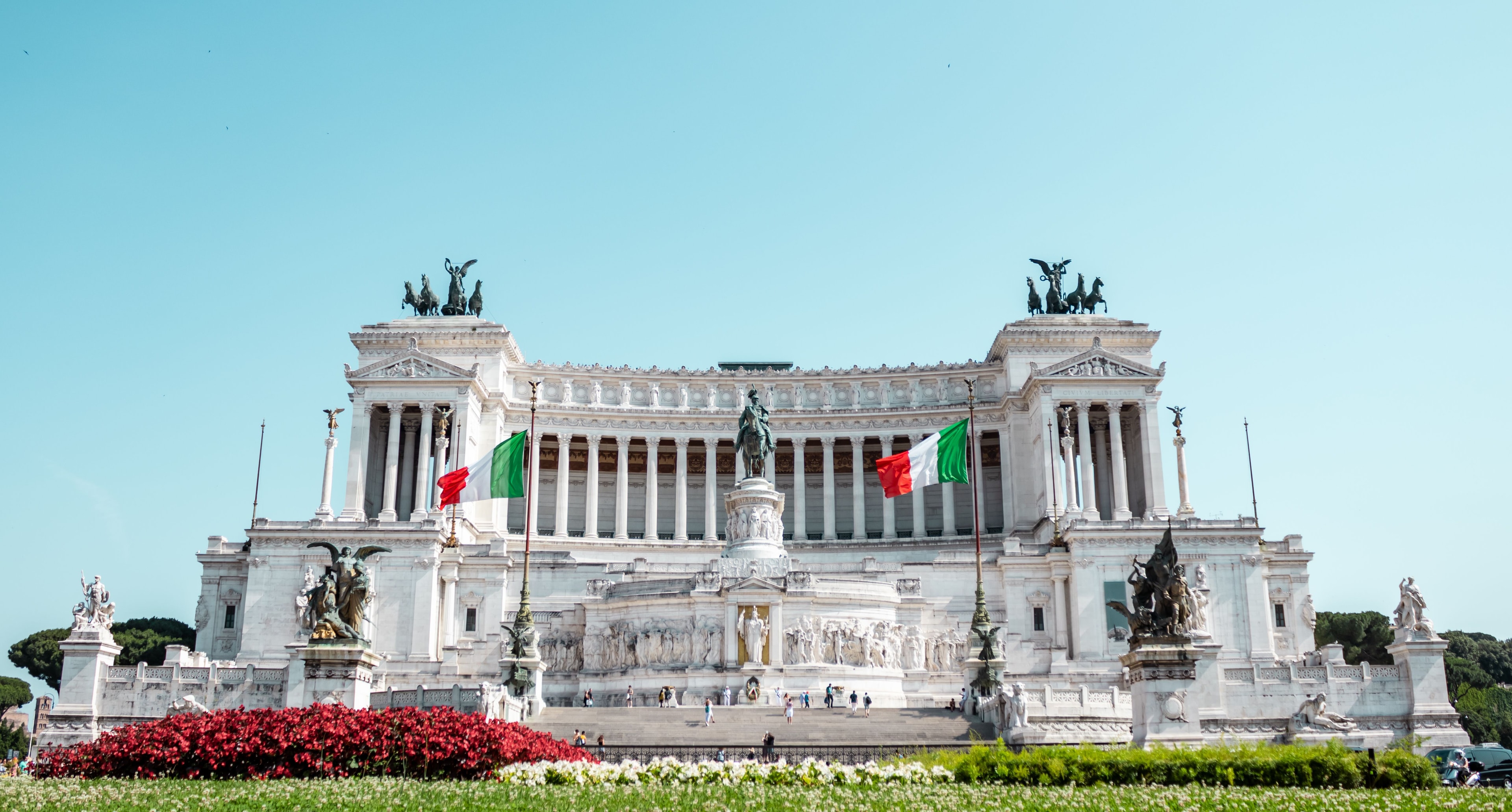 Altare della Patria a Roma con le bandiere italiane e aiuole in fiore